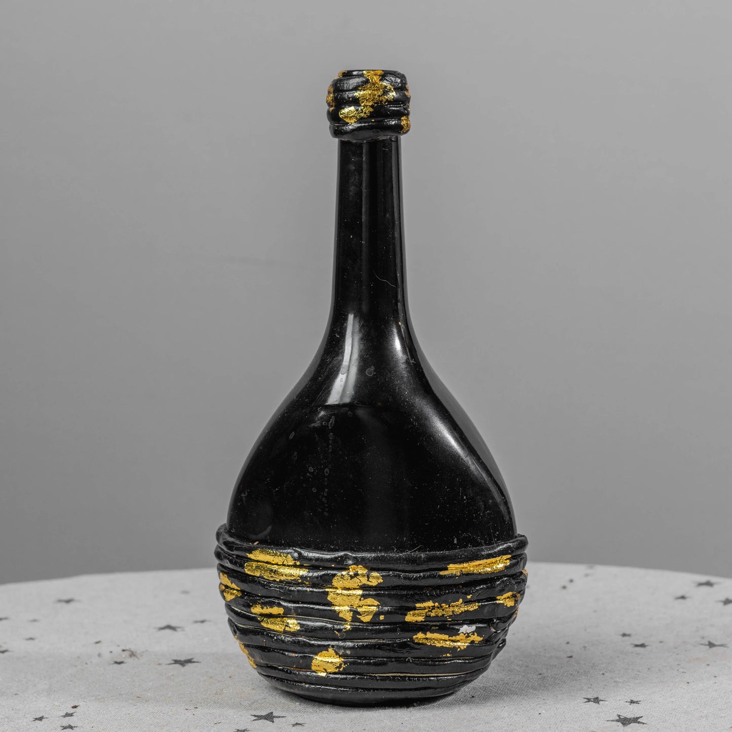 Garrafa preta com detalhes dourados